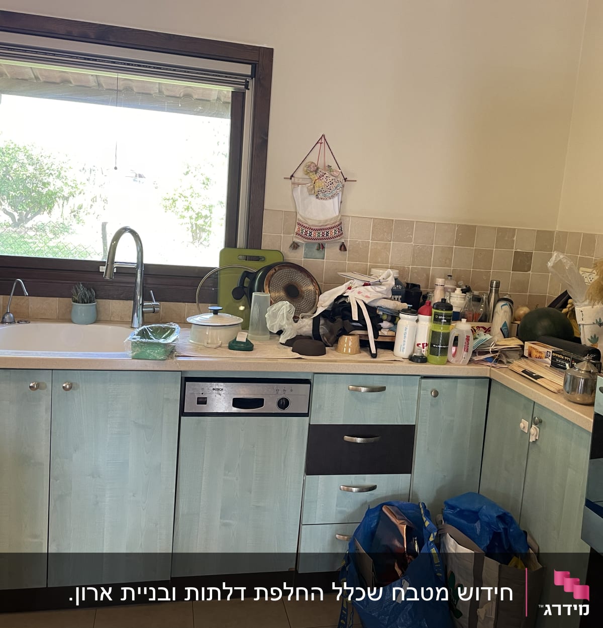 מטבח עם כיור, ברז, כלים ומכשירי חשמל על השיש